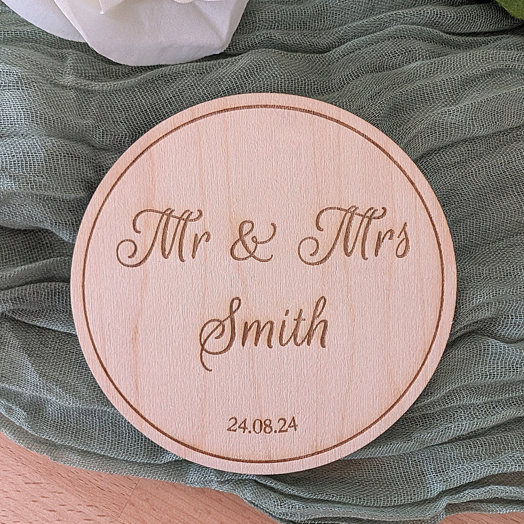 Round wooden plaque with 'Mr & Mrs Smith' engraving on a textured green fabric background