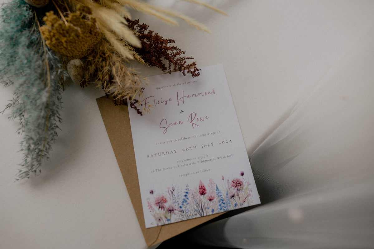 Wedding invitation card with floral design on a white surface