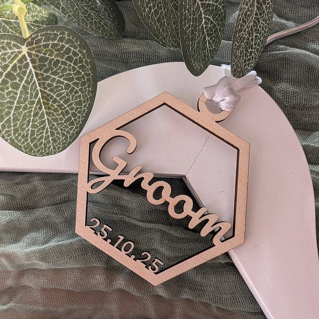 Hexagonal wooden plaque with 'Groom' and date on a green leafy background