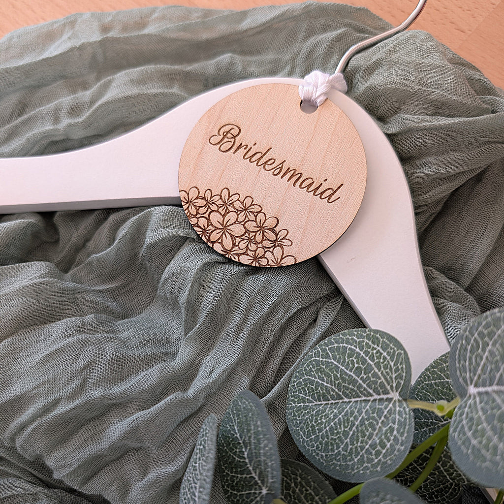 Wooden spoon with 'Bridesmaid' tag on a green fabric background