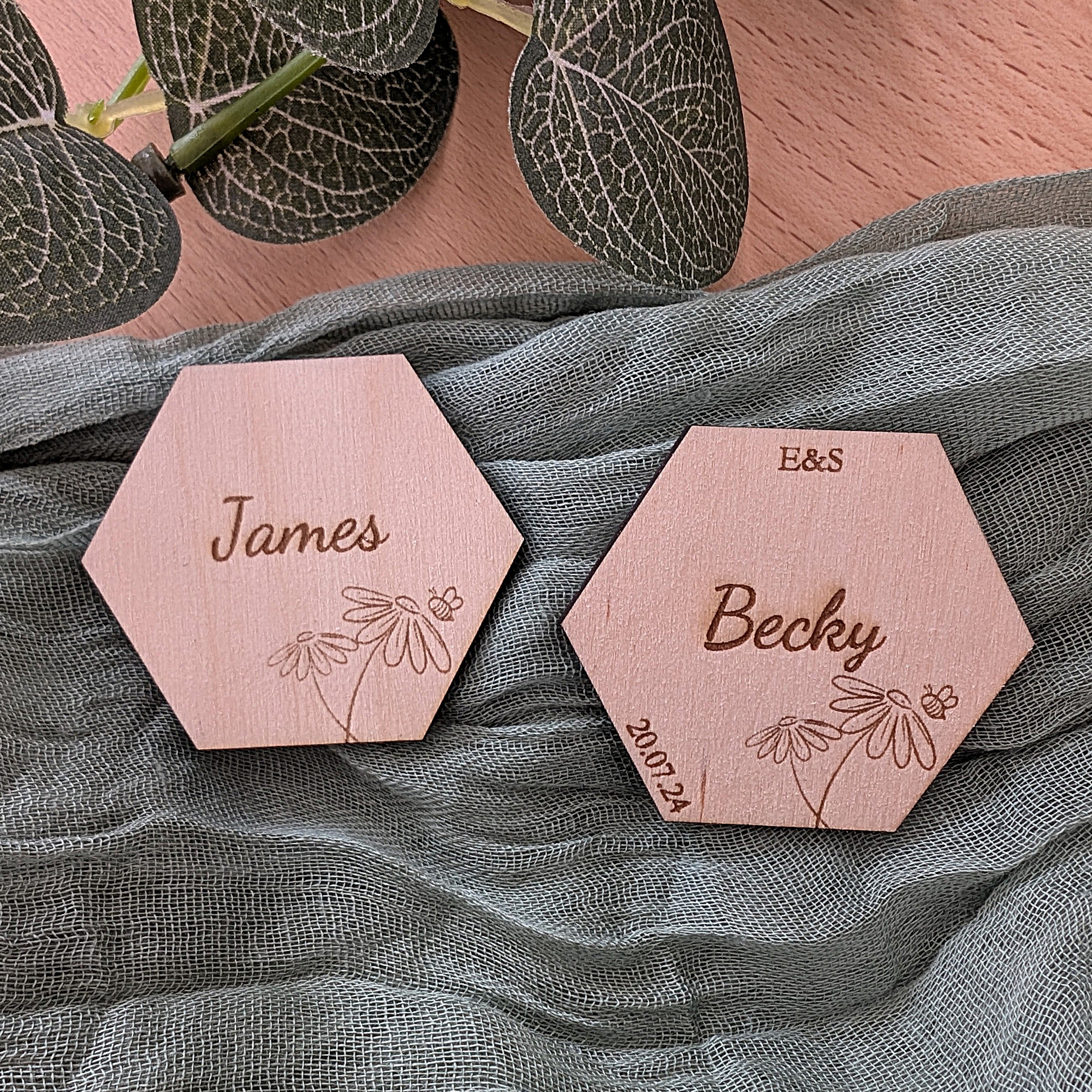 Hexagonal wooden name tags with engraved names on a textured fabric background